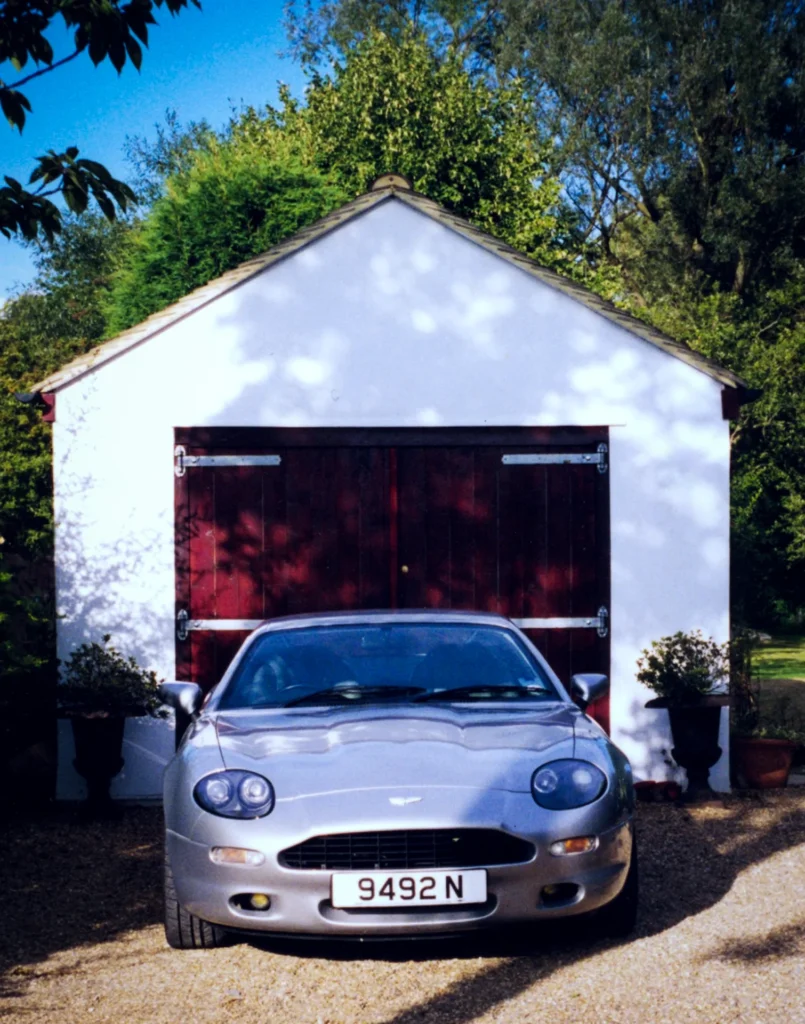 Aston-Martin-DB7-Manual-1995-Forte-Vision-In-front-of-white-garage-garden-summer