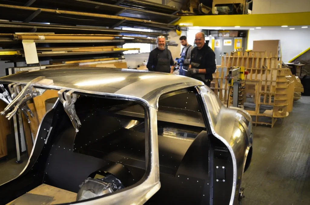 Mouland-and-Yates-Forte-Vision-welding-aluminium-bespoke-car-body-buck-three-metalworkers-smiling
