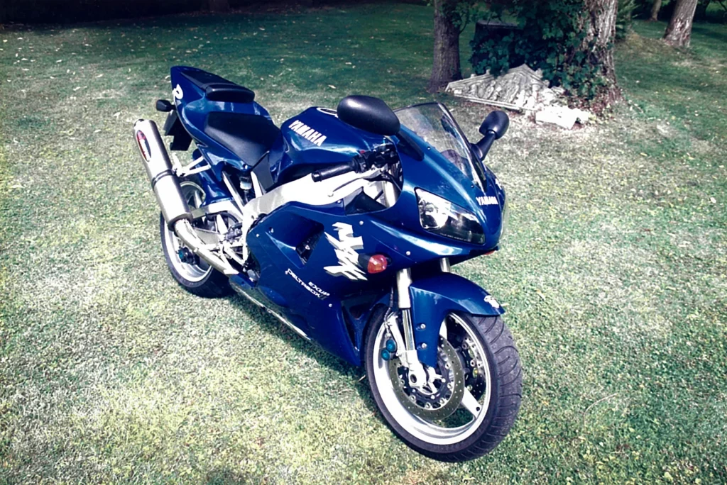Yamaha-R1-1998-blue-Akrapovic-exhaust-summer-garden-setting